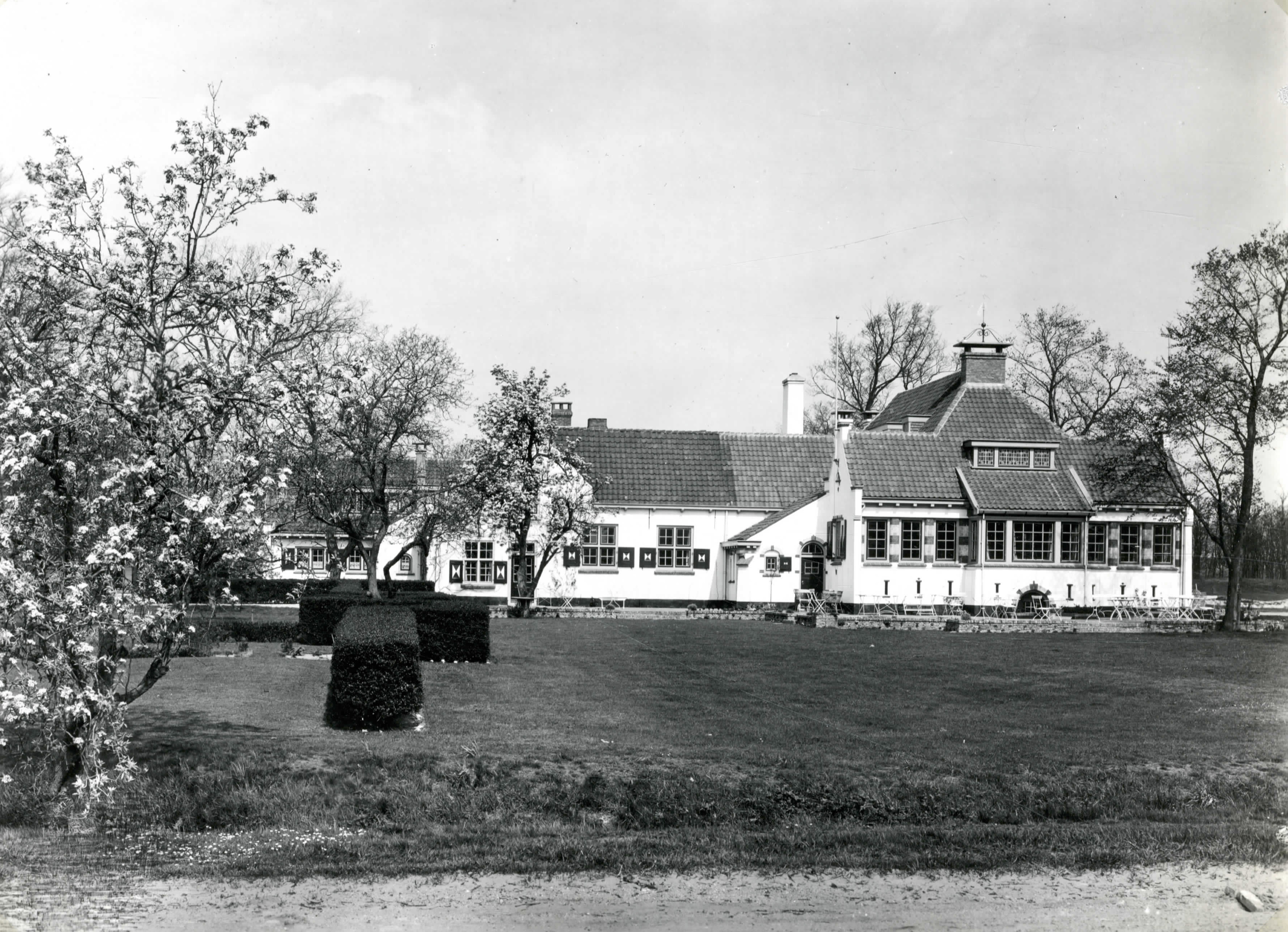 Clubhuis naast bloeiende boomgaard