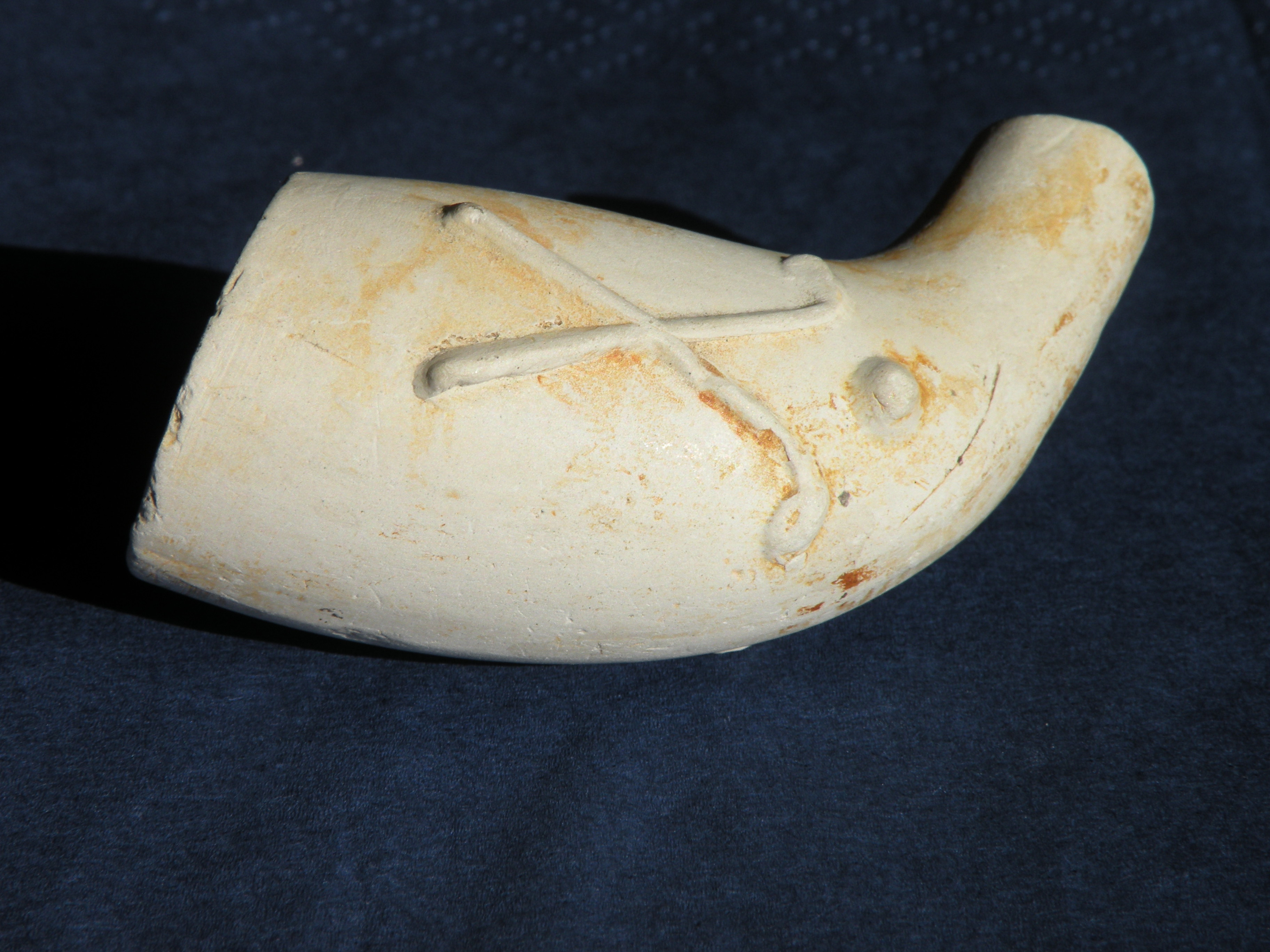 Pijpenkop met twee gekruiste colfstokken en een bal