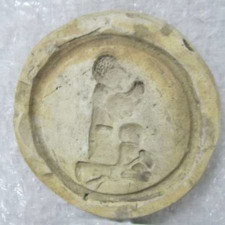 Knielende figuur met kolfstokken (?) op pataconvorm